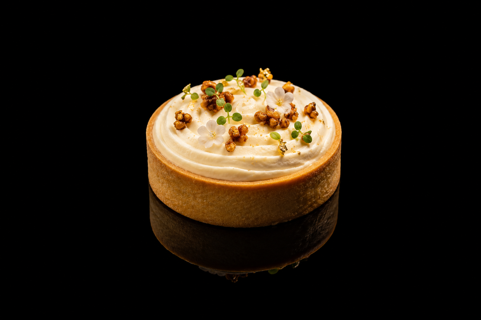 Tartare crèmeux décoré de petites fleurs blanches, de graines dorées et de petites feuilles vertes, présenté sur un fond noir.