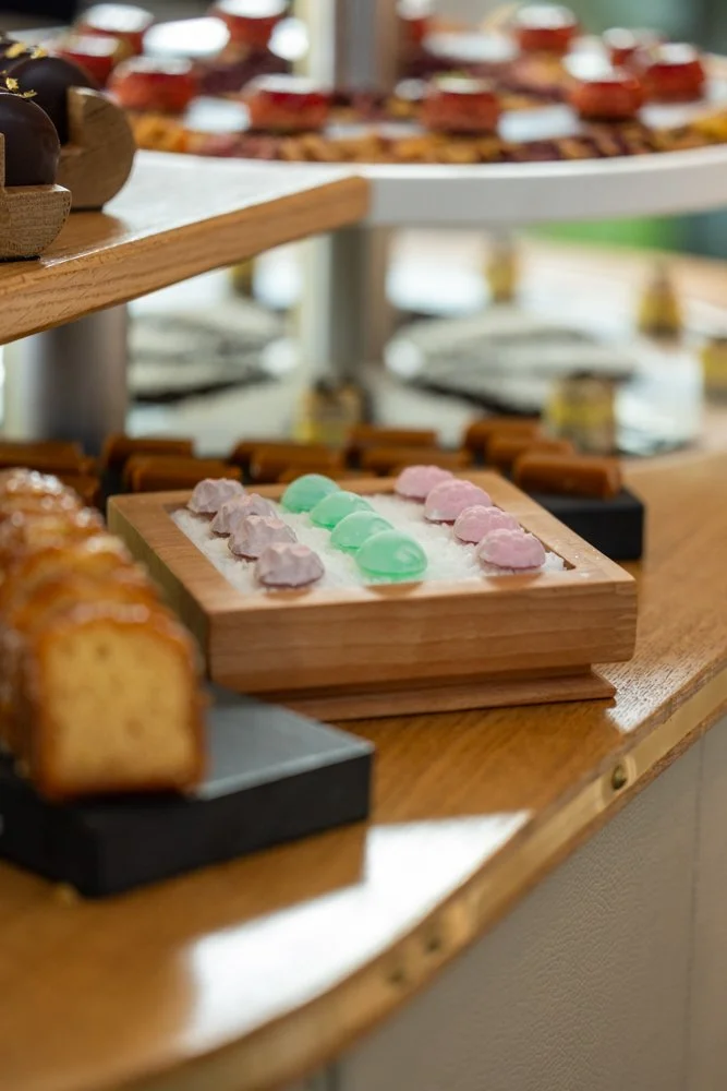 Plateau de savons colorés en forme de coquillage sur une table en bois.