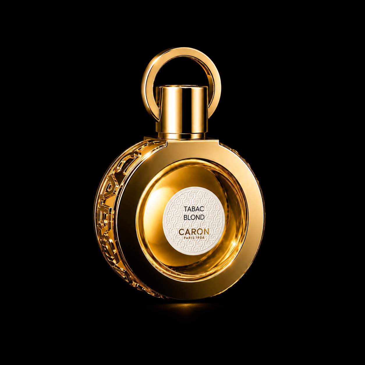 Flacon de parfum orné de détails en or, avec étiquette blanche indiquant 'Tabac Blond' et 'Caron' sur fond noir.