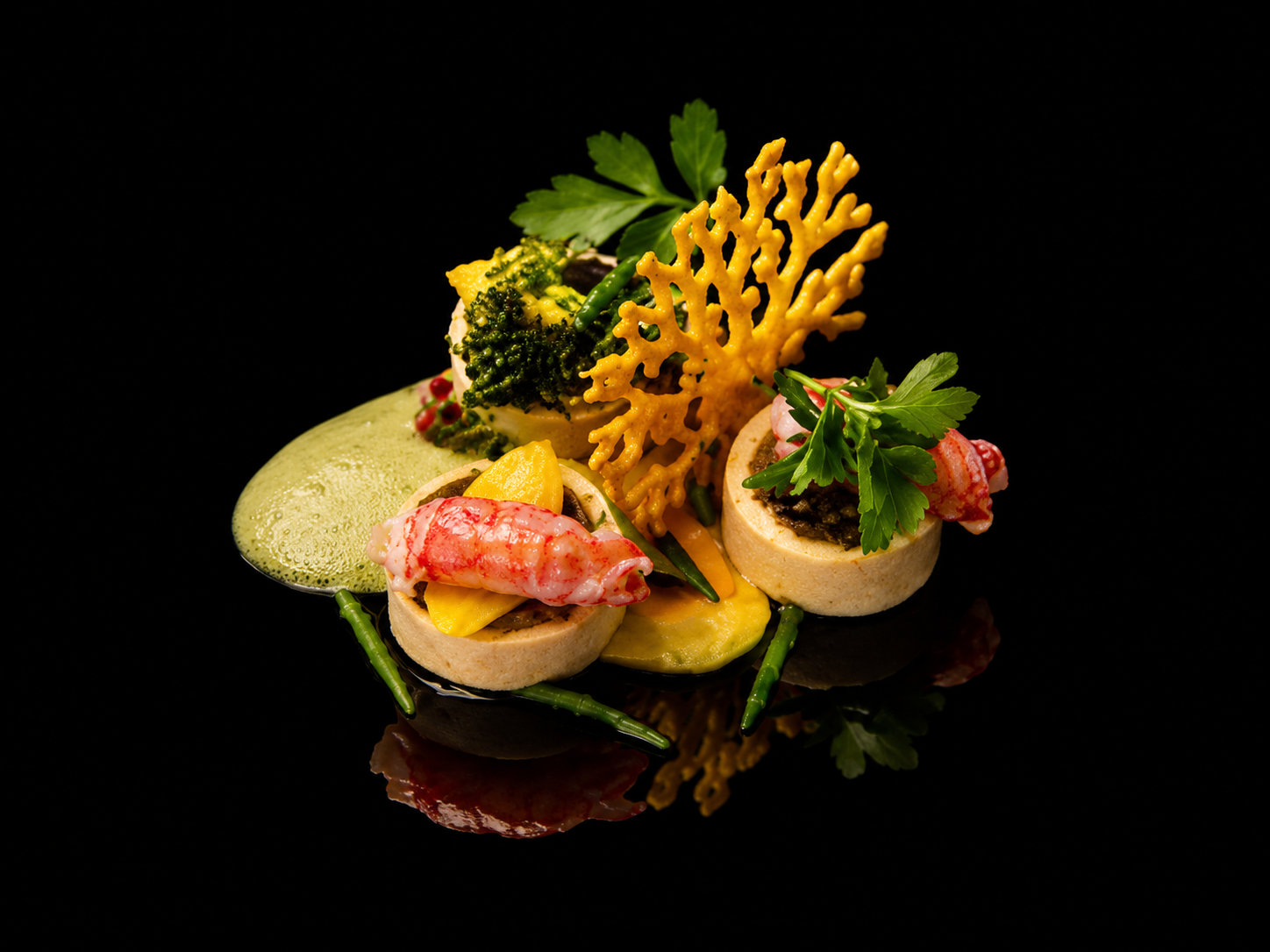 Assiette gastronomique avec des fruits de mer, légumes verts, fruits, et garnitures décoratives sur fond noir
