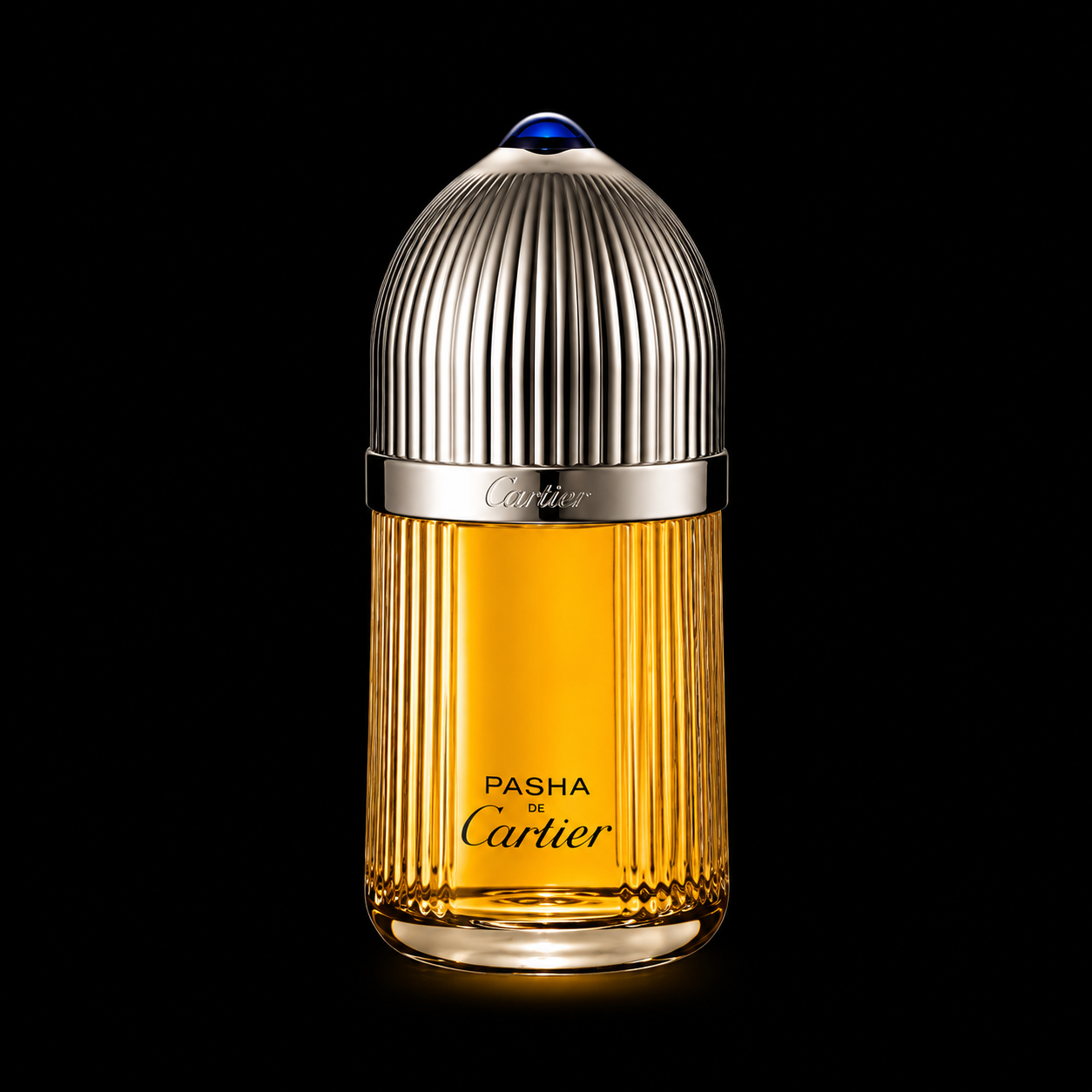Flacon de parfum de luxe avec une bouteille transparente contenant un liquide orange, orné d'un capuchon métallique argenté avec des rayures verticales et le nom Cartier gravé, sur un fond noir.