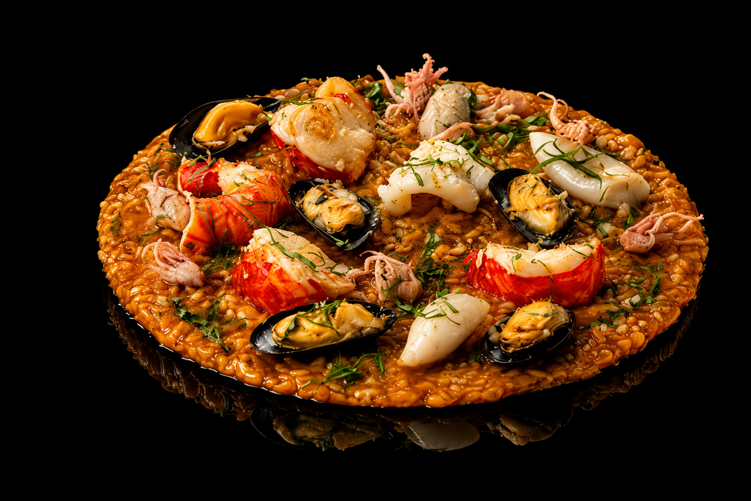 Paella de fruits de mer avec crevettes, calamars, moules et riz safrané, garnie de herbes, sur fond noir