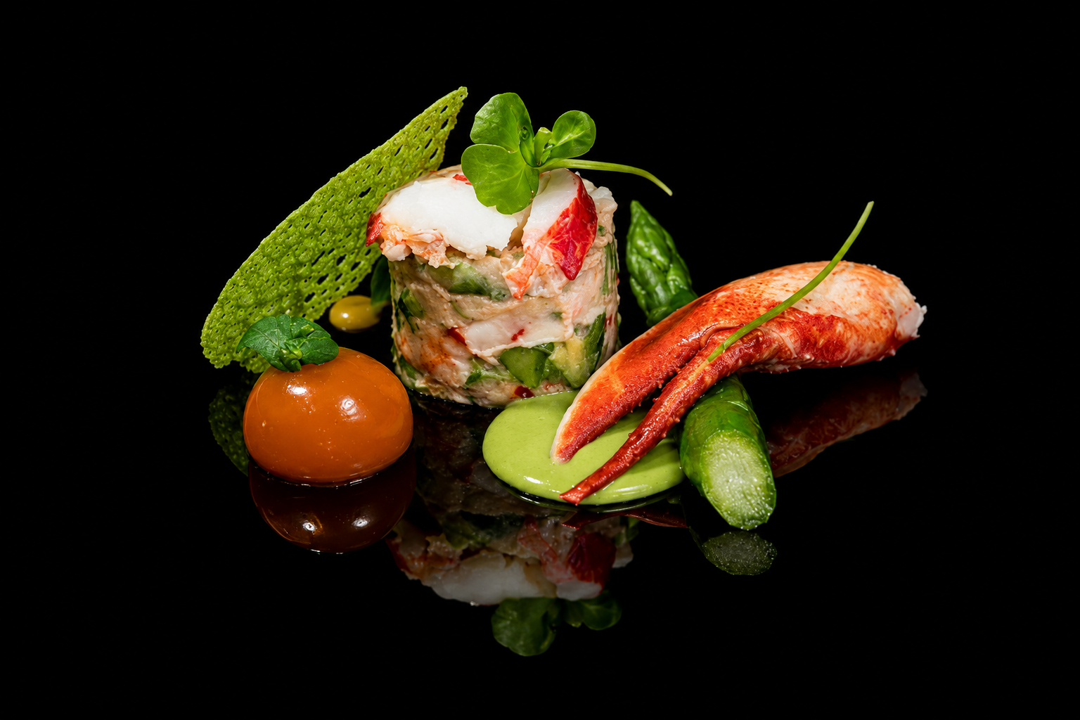 Assiette gastronomique composée d'une part de tarte froide de légumes, de crevettes et de sauce verte, accompagnée de légumes verts, d'une tomate cocktail et d'une feuille de salade, sur un fond noir