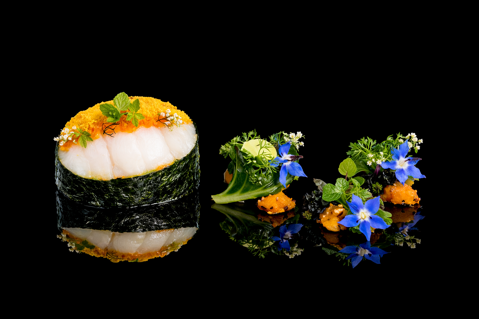 Gros plan sur un sushi avec une garniture de poisson blanc, de caviar d'œufs, de feuilles de menthe et de fleurs comestibles, accompagné de deux petites présentations avec des fleurs bleues et des herbes, sur fond noir reflétant le plat.