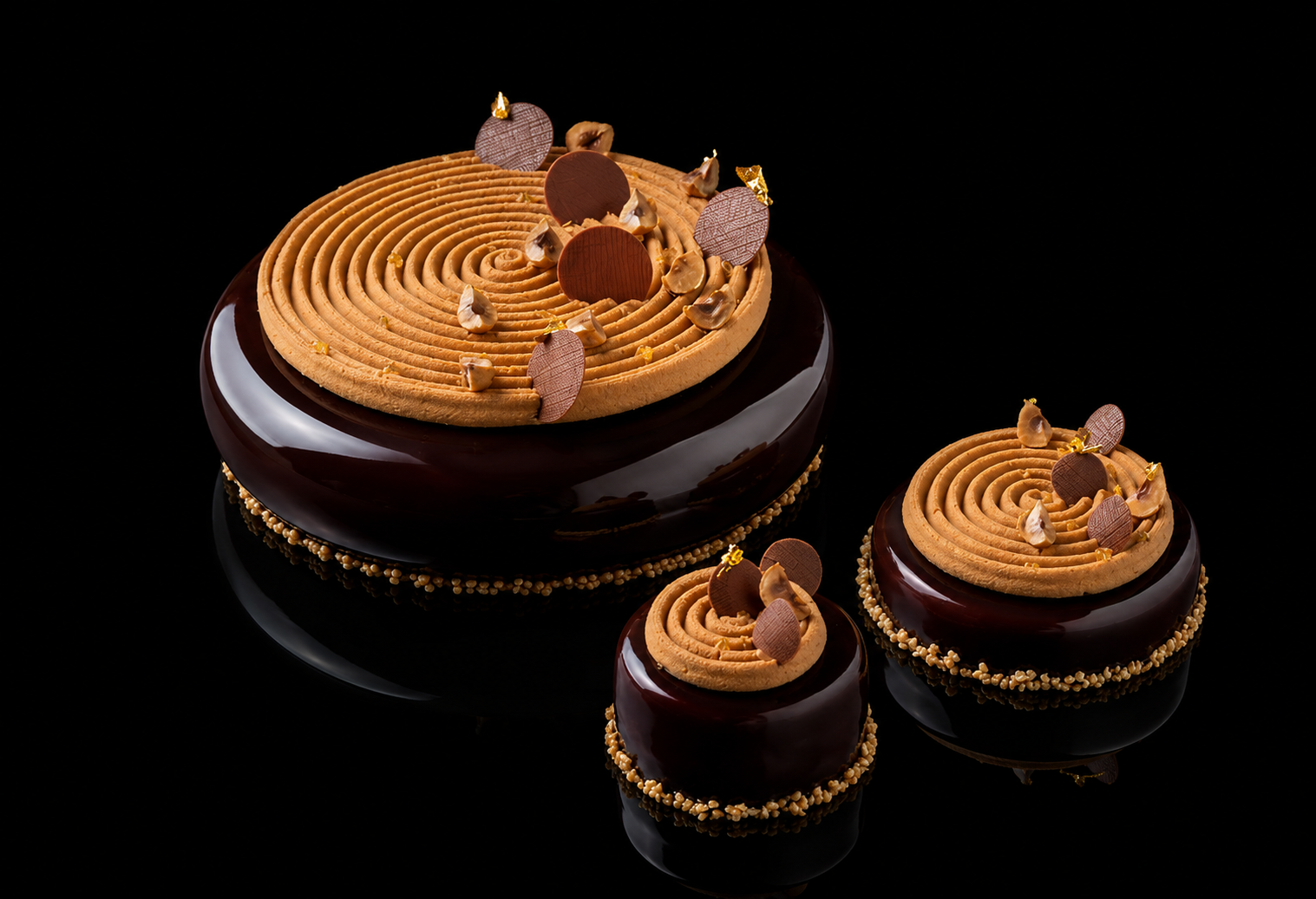 Trois desserts élégants avec glaçage chocolat et décorations en chocolat et or.