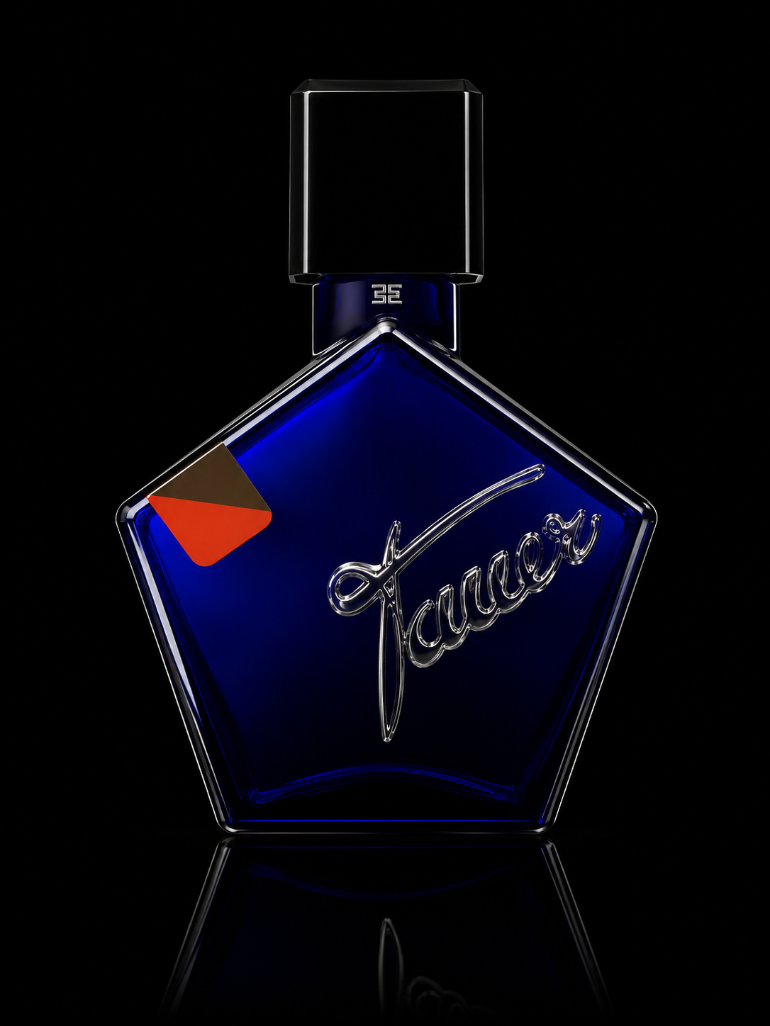 Flacon de parfum bleu en forme de pentagone avec texte 'Jacques' en écriture cursive argentée sur le devant, fond noir, reflet au bas de l'image.