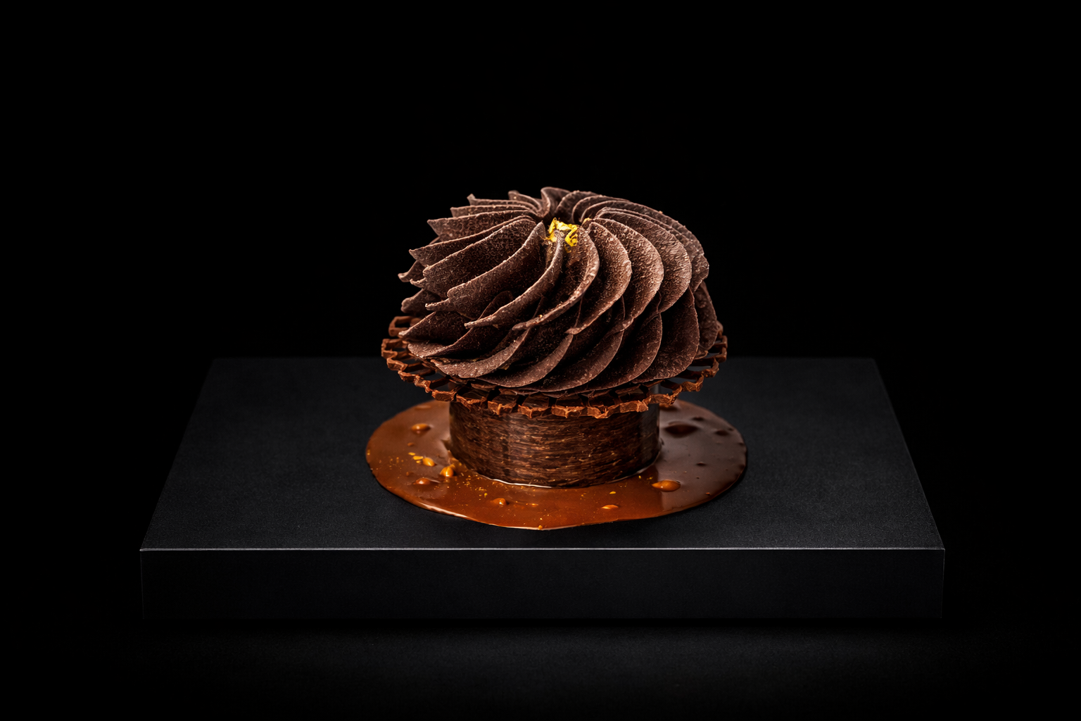 Gâteau au chocolat décoré avec de la crème au chocolat en spirale, posé sur une plaque noire avec un fond noir.