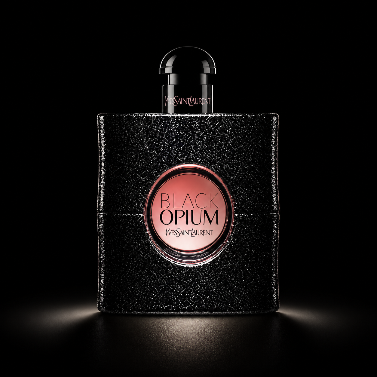 Une bouteille de parfum Yves Saint Laurent Black Opium avec un design noir scintillant et un cercle rose au centre, sur fond noir.