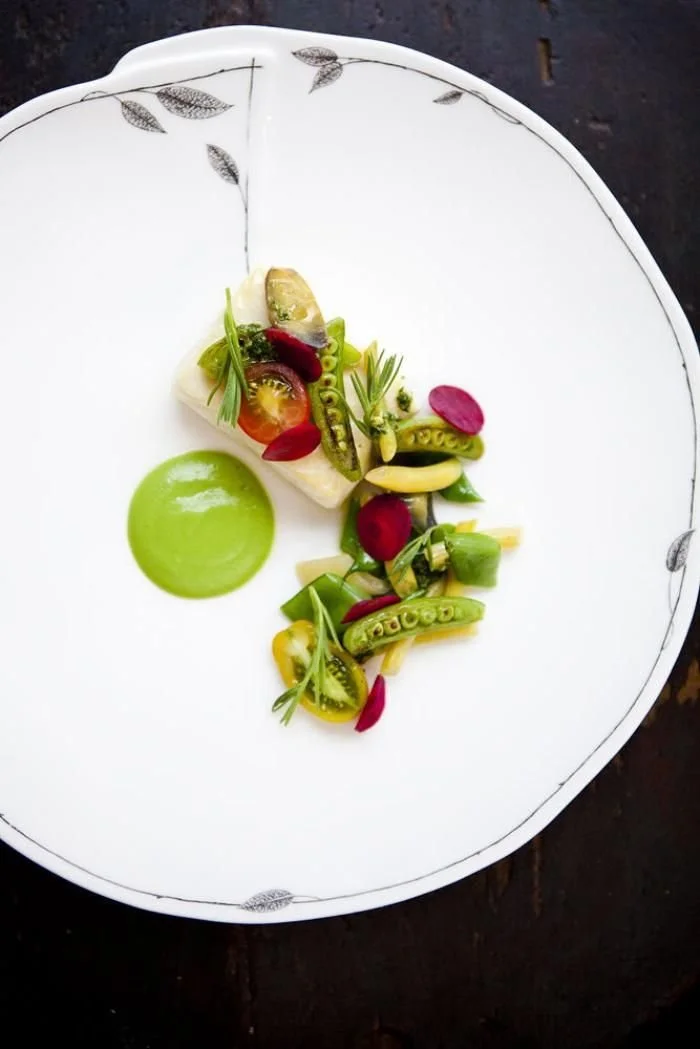 Assiette de salade végétale avec des tomates, des haricots verts, de la sauce verte et des garnitures végétales