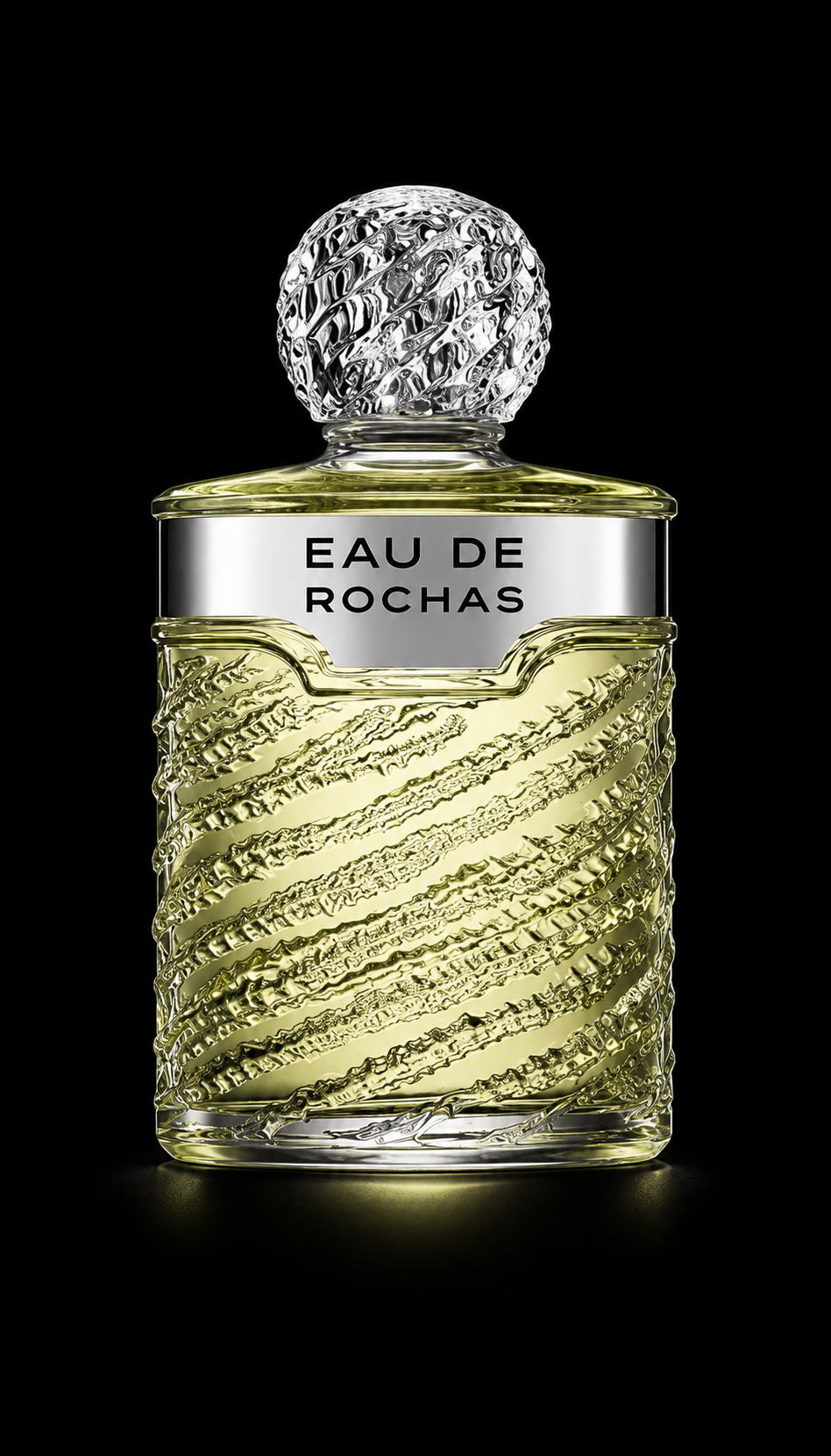 Flacon de parfum transparent avec un bouchon en verre sculpté, contenant un liquide jaune pâle, étiqueté "Eau de Rochas".