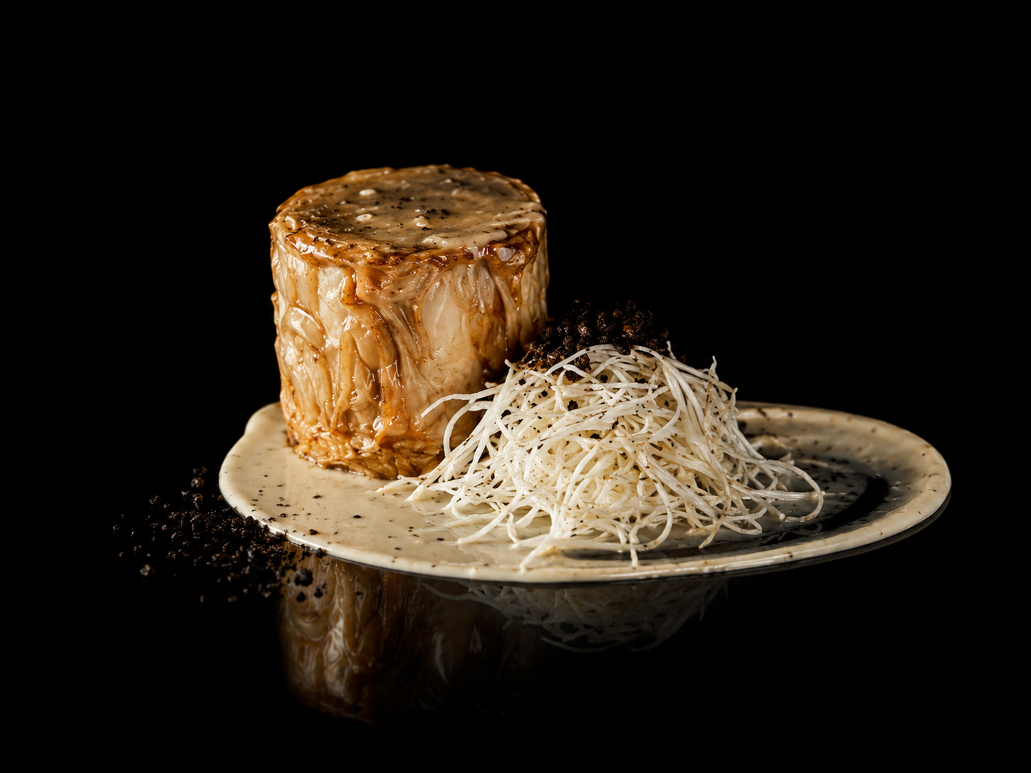 Un plat gourmet avec un morceau de viande nappé de sauce, accompagné de filaments de fromage ou de légumes, présenté sur une assiette beige sur fond noir.