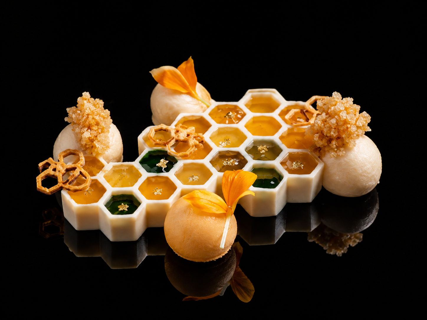 Dessert élégant avec un motif en nid d'abeille, comprenant des sphères blanches, des fleurs orange, des perles de caramel, et des éléments en forme de miel ou gelée