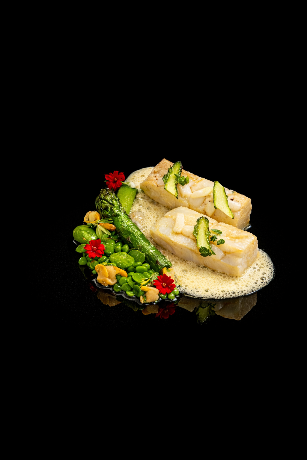 Filet de poisson blanc cuit, garni de tranches de concombre et servi avec une sauce légère, accompagné de légumes verts, petits pois, asperges, et garnitures de fleurs rouges sur fond noir.