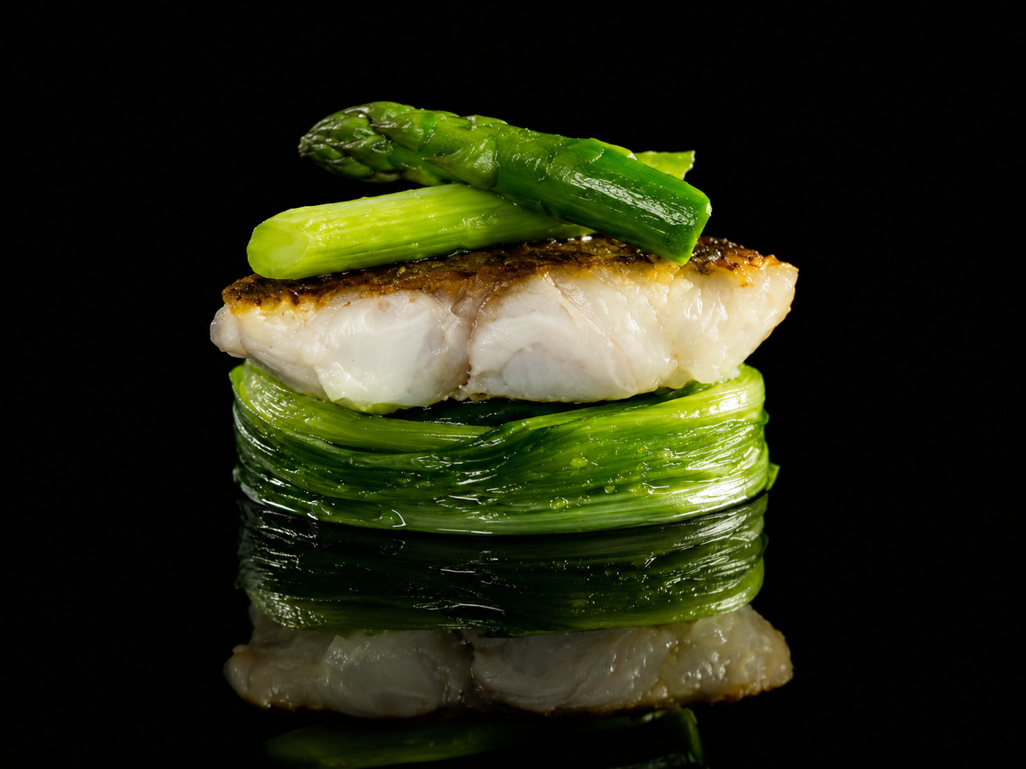 Poisson blanc cuit avec de l'asperge et des brins de ciboulette, présentation gastronomique sur fond noir.