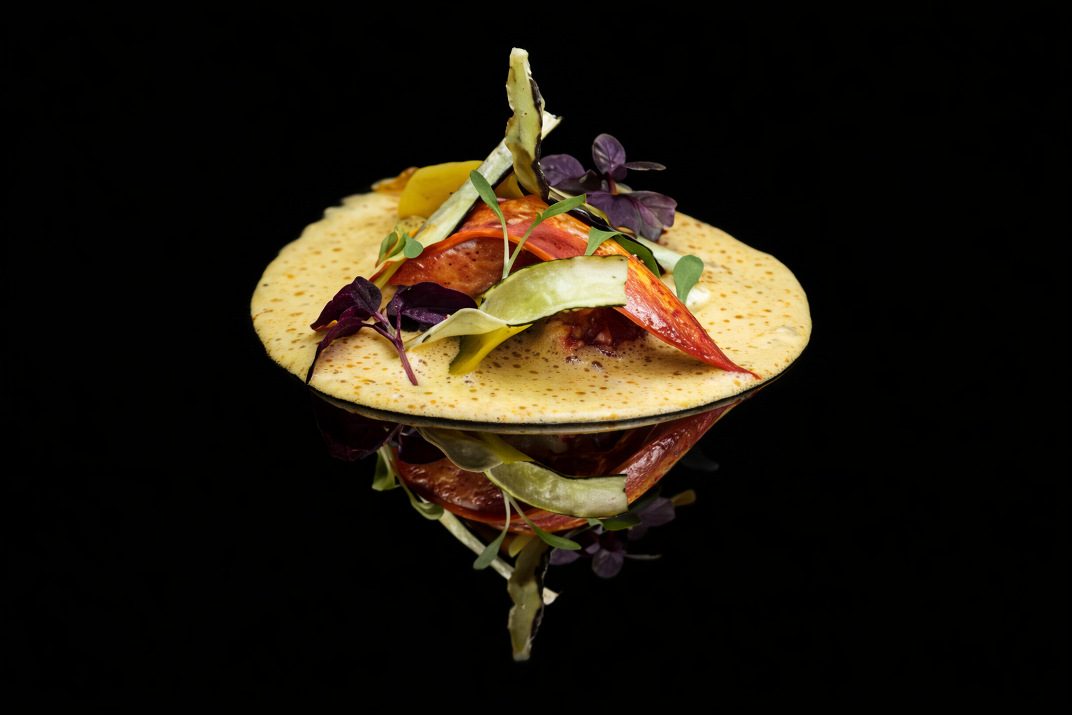 Assiette de plats végétariens avec avocat, tomate, microgreens sur un lit de purée ou sauce, ambiance noire