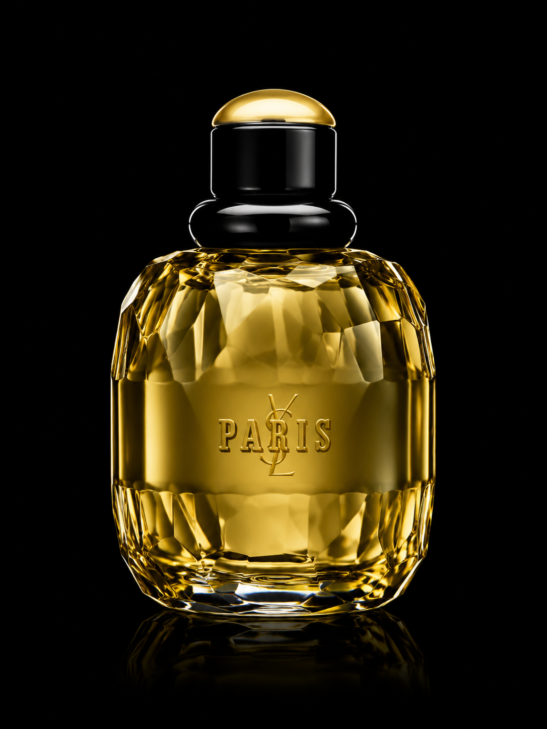 Flacon de parfum doré avec inscription « PARIS » et logo Yves Saint Laurent, sur fond noir.