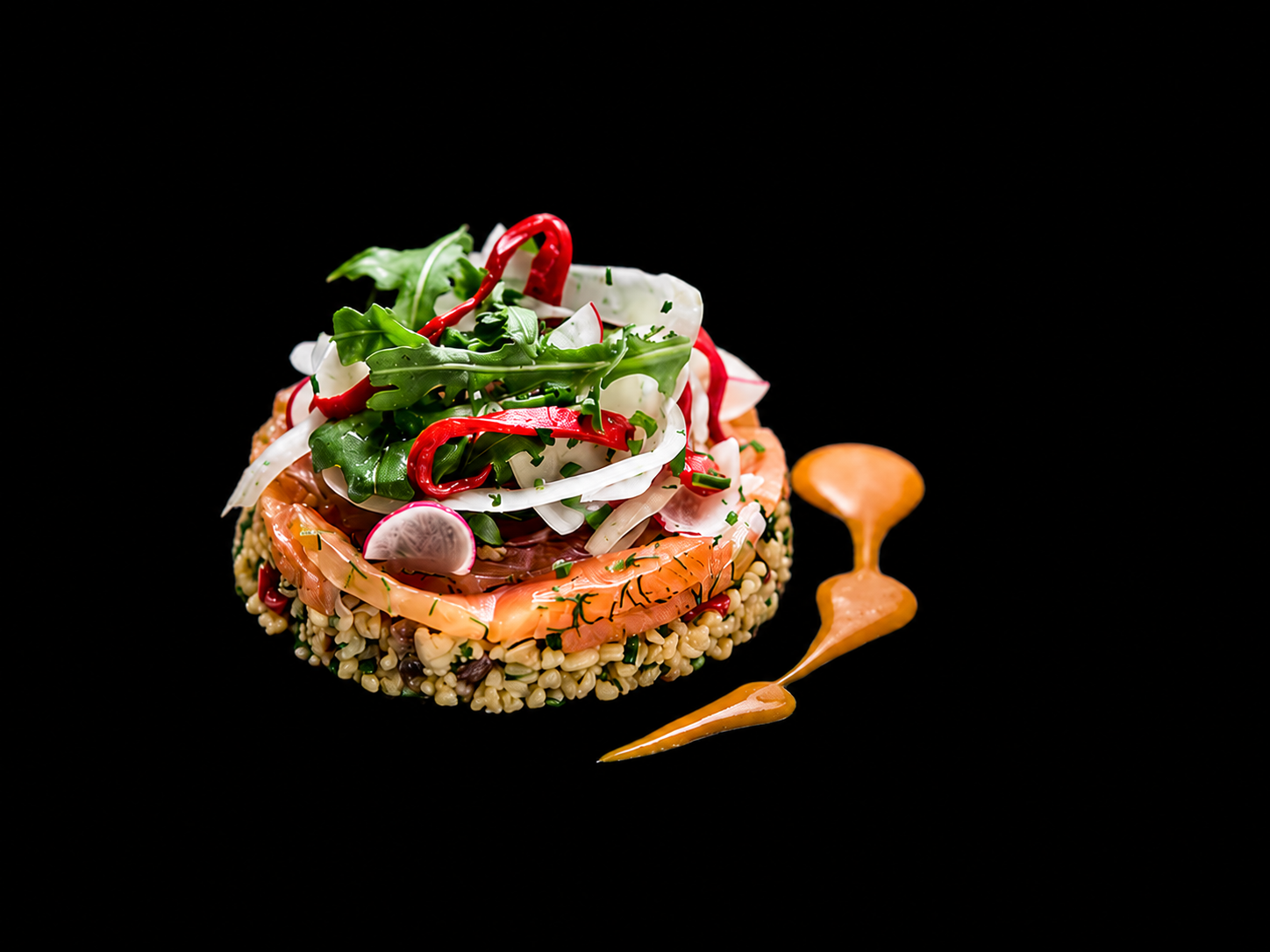 Assiette de salade avec saumon, légumes frais, radis, et graines, servie avec une sauce orange