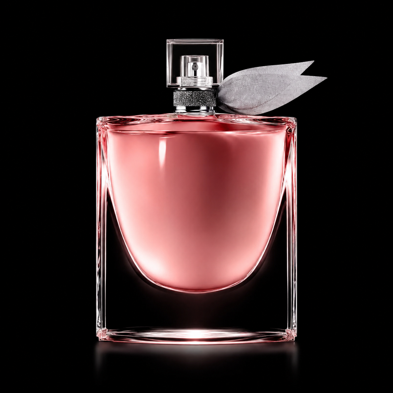Flacon de parfum rose transparent avec une boucle d'oreille en forme de feuille argentée.