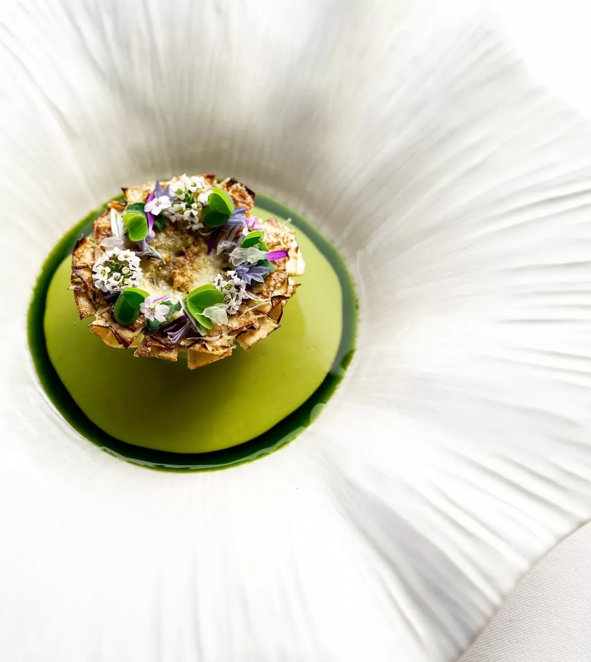 Un plat gourmet présenté dans une assiette blanche avec une mise en scène élégante.