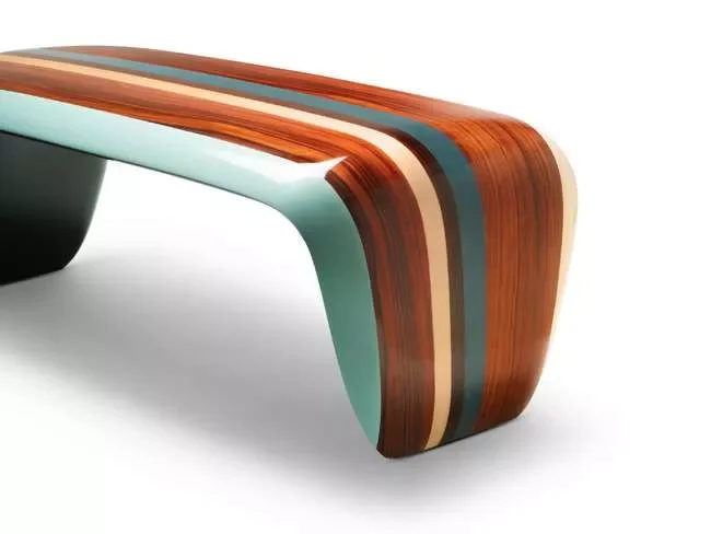 Une table moderne en bois aux couleurs bleu, marron et crème avec un design courbé.