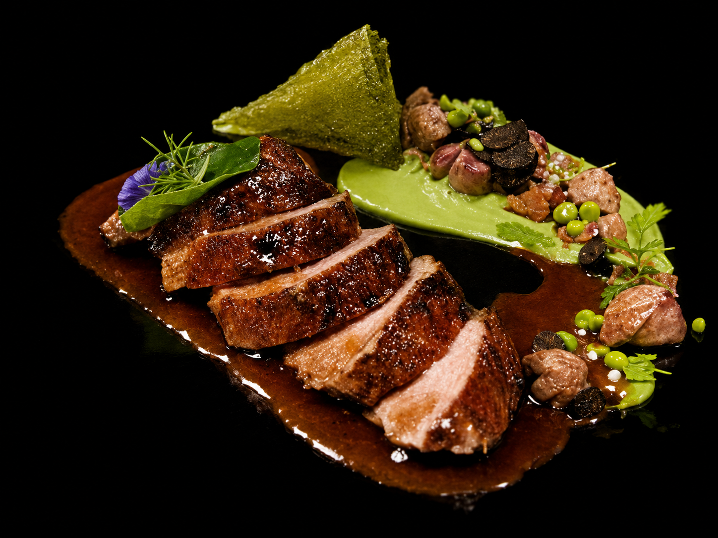 Filet de viande rouge tranché avec une sauce brune, accompagné d'une purée verte, garnitures végétales et herbes aromatiques, présenté sur une assiette noire