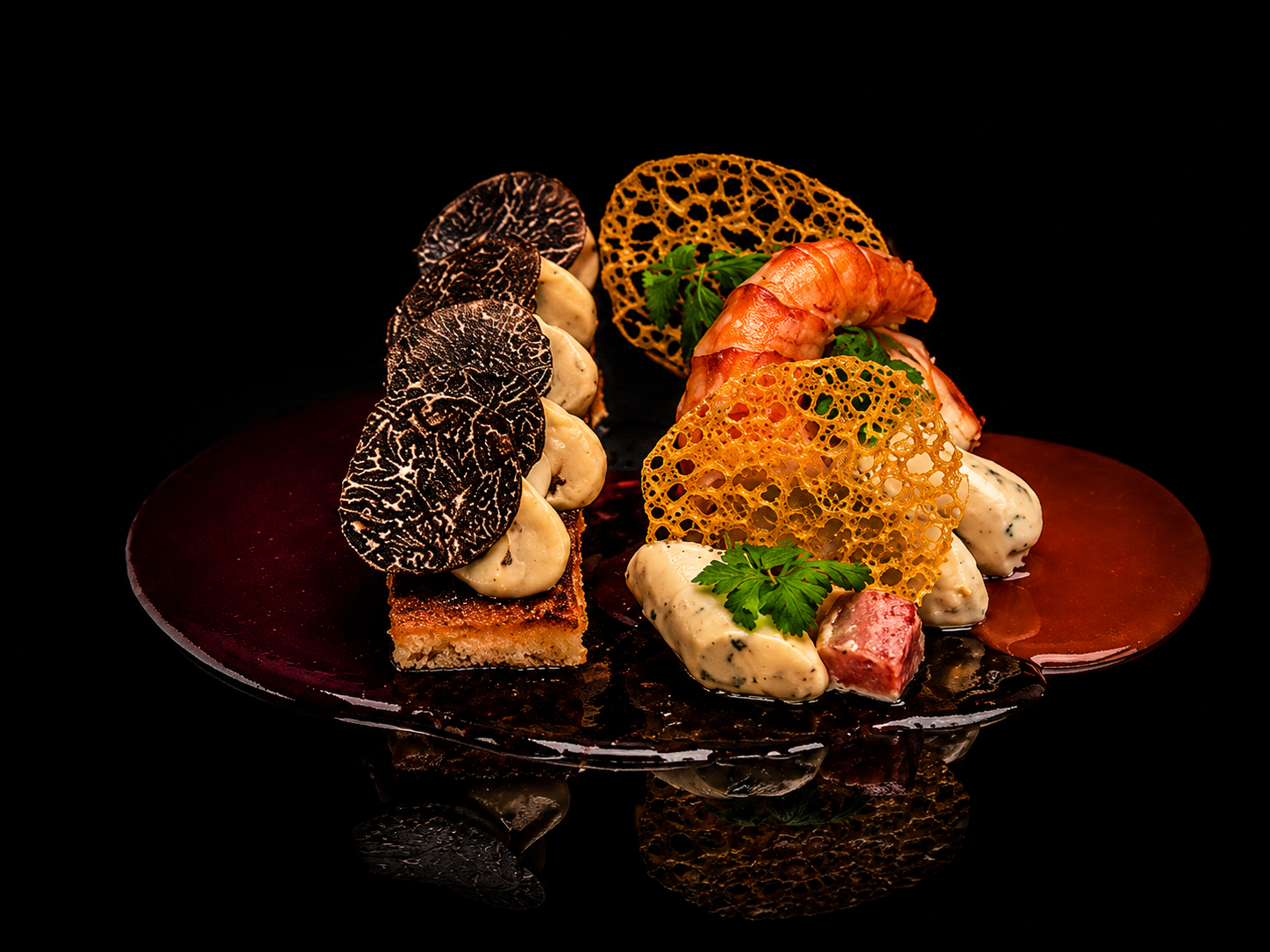 Plat gastronomique avec morceaux de viande, sauce, mousse, feuilles de persil, chips croustillants, terrines, et champignons sur une assiette noire