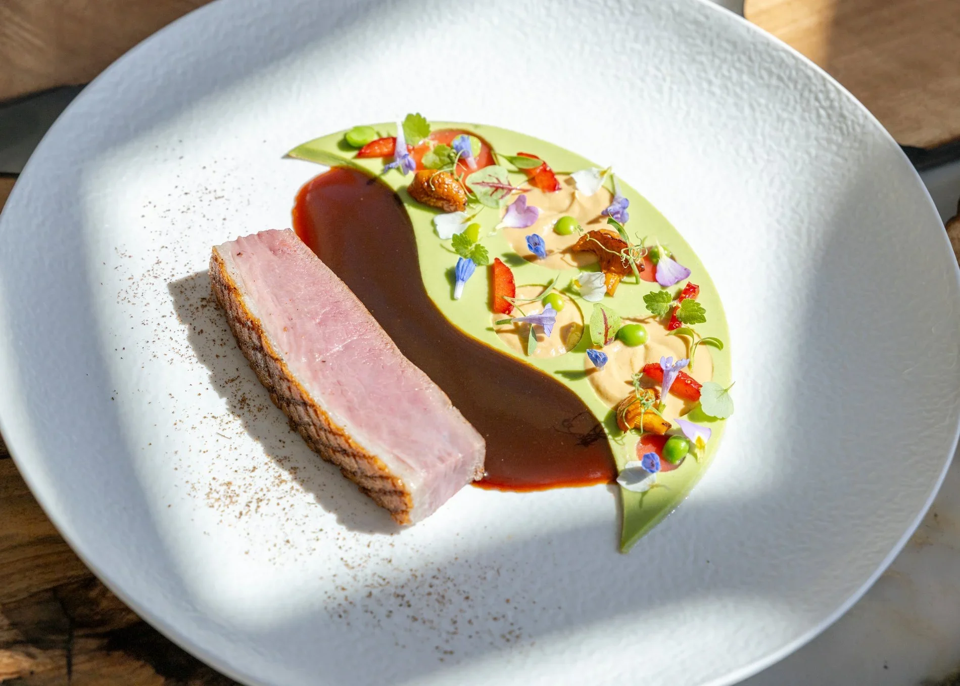 Assiette de filet de poisson en croute avec sauce terrarienne et décoration florale