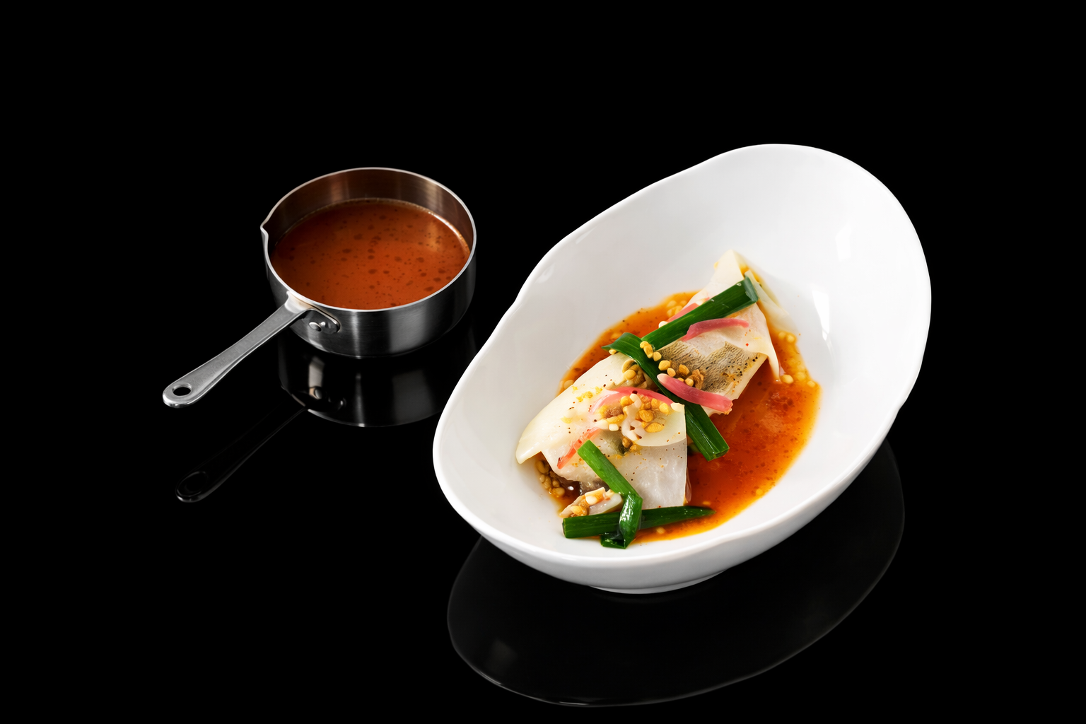 Plat de sashimi de poisson avec sauce, servi dans un bol blanc avec des herbes et des graines, sur fond noir.