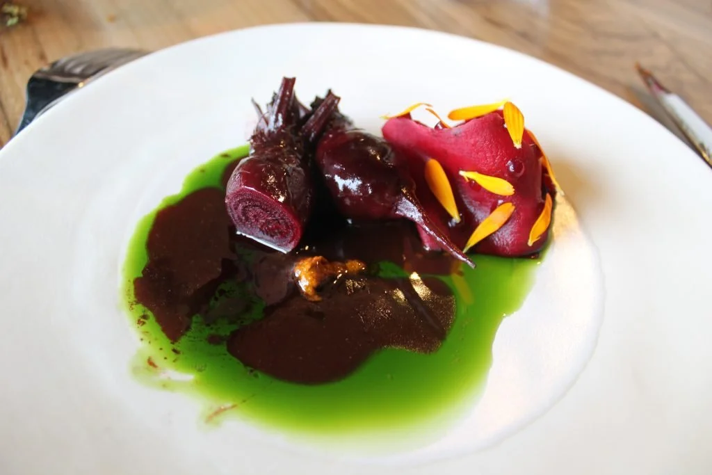 Assiette avec un plat de légumes colorés, purée de légumes, et sauce verte