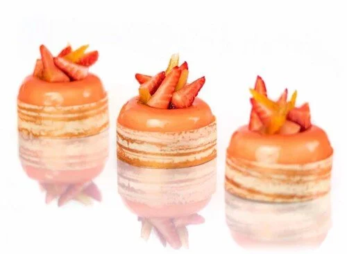 Trois petits gâteaux décorés avec des fruits tranchés, garnis de morceaux de fruits frais.