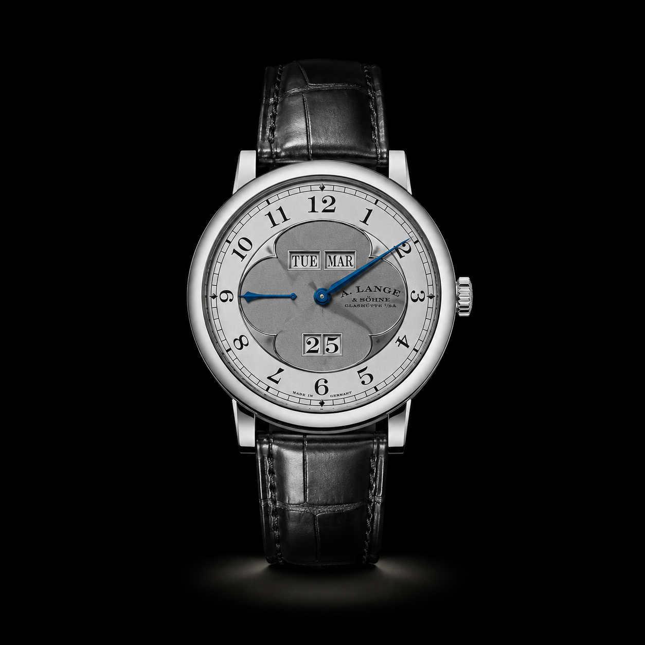 Une montre de luxe avec un cadran argenté, des aiguilles bleues, affichant l'heure 9:12, avec la date et le jour.
