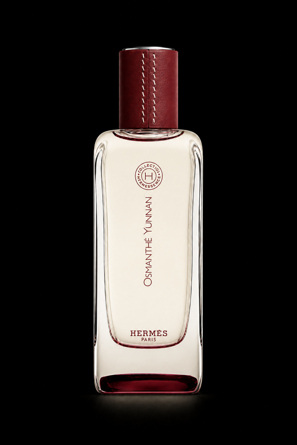 Flacon de parfum Hermès 'Osmanthé Yunnann' avec capuchon en cuir rouge, fond noir.