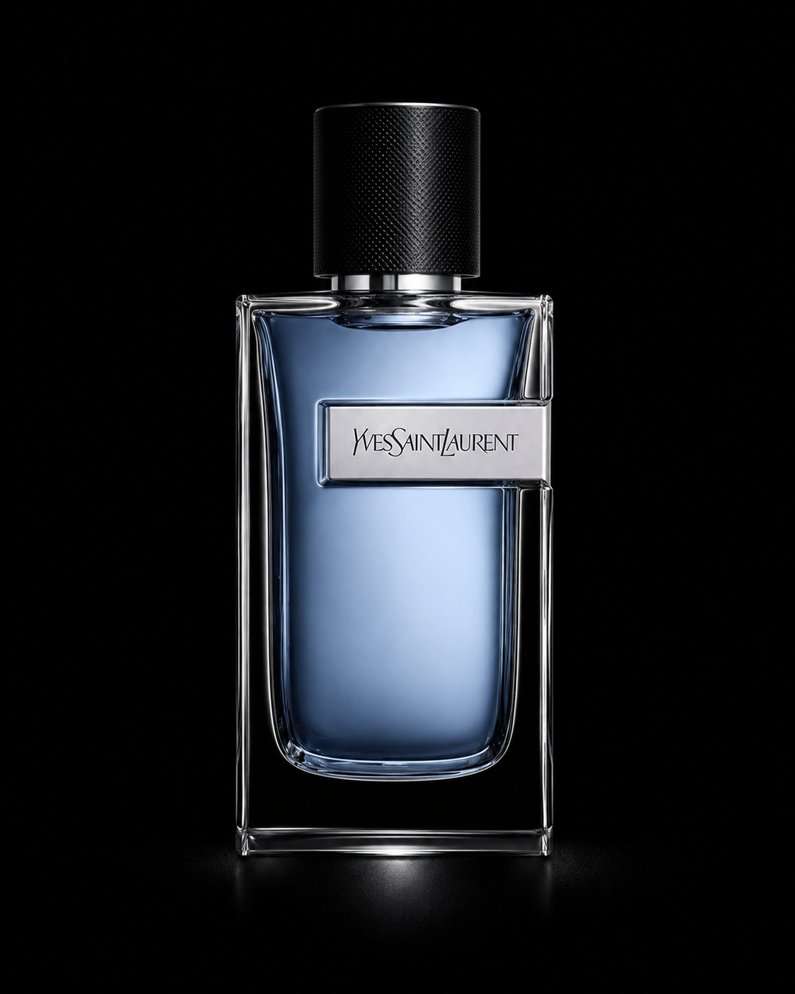 Flacon de parfum Yves Saint Laurent, rectangulaire avec un bouchon noir, contenant un liquide bleu, sur un fond noir.
