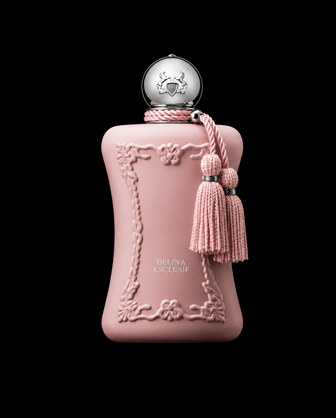 Une bouteille de parfum rose avec des détails décoratifs en relief et un ruban en cordelette, accompagnée de deux pampilles, sur fond noir.