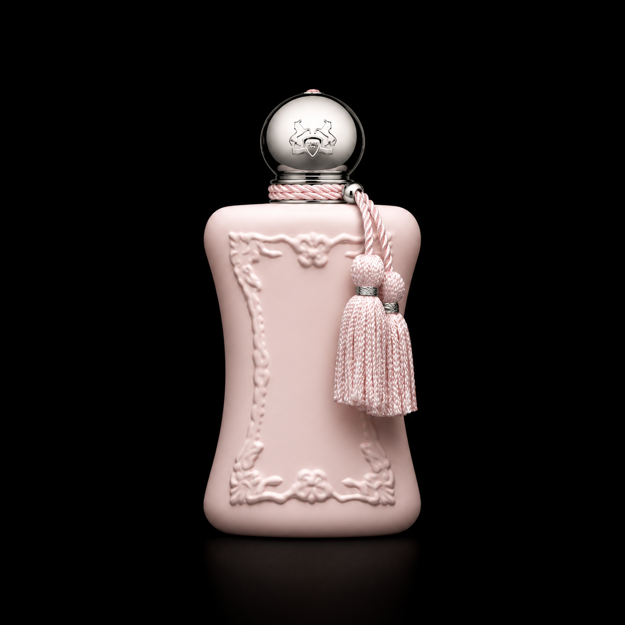 Un flacon de parfum rose pâle avec des détails ornementaux, un pompon et une chaîne de tissu rose, sur un fond noir.