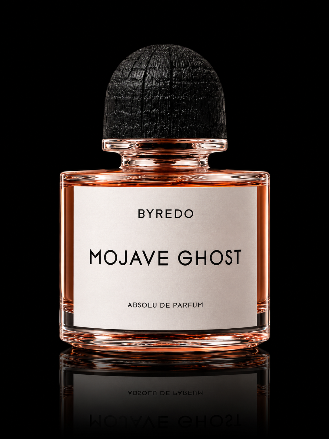 Une bouteille de parfum Byredo Mojave Ghost avec un fond noir, mettant en valeur la bouteille en verre transparent avec liquide rose pâle et un bouchon en bois noir.