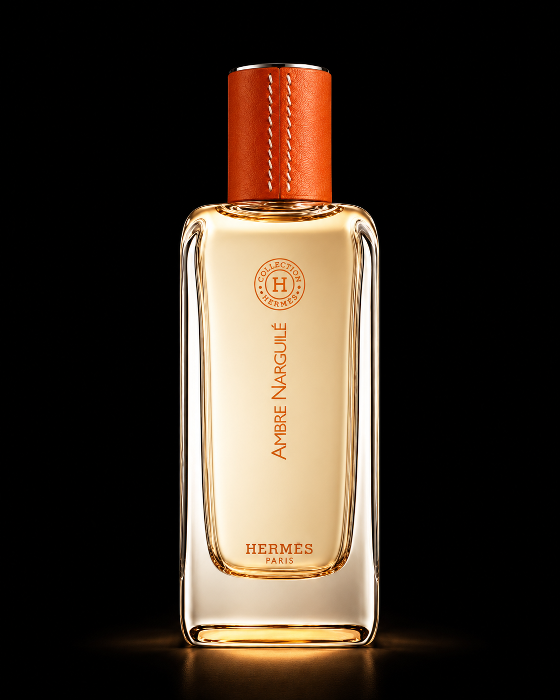 Flacon de parfum Hermès Ambre Narguilé avec un capuchon en cuir brun, posé contre un fond noir, illuminé de lumière chaude refletant sur le verre.