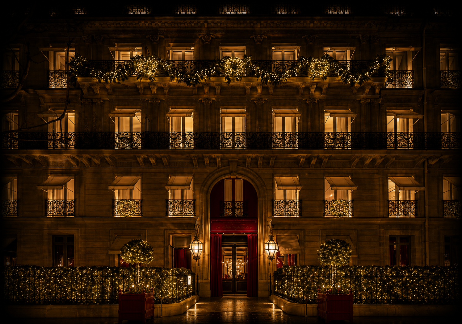 Un bâtiment élégant décoré pour Noël, avec des guirlandes lumineuses, des guirlandes vertes, des arbres décorés et des fenêtres illuminées, vue nocturne.
