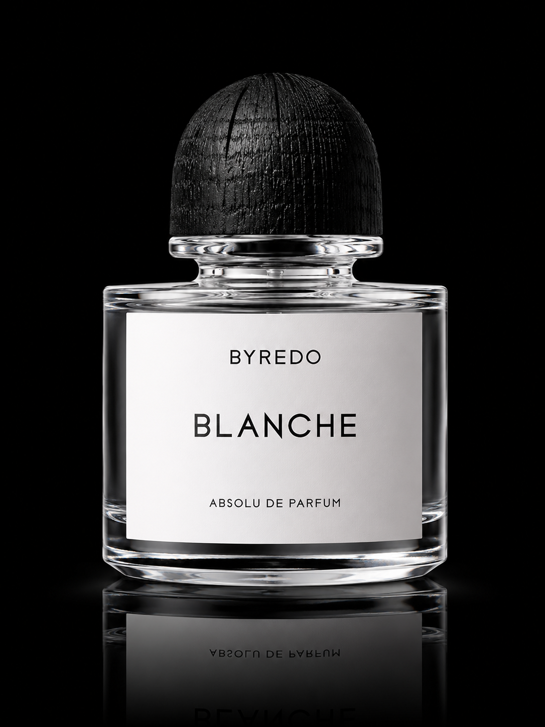 Flacon de parfum transparent avec bouchon noir, étiquette blanche avec texte noir"BYREDO BLANCHE ABSOLU DE PARFUM"