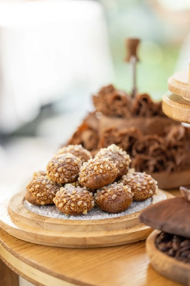 Gros plan sur des croquettes de dessert avec des crumbs, posées sur une assiette en bois.