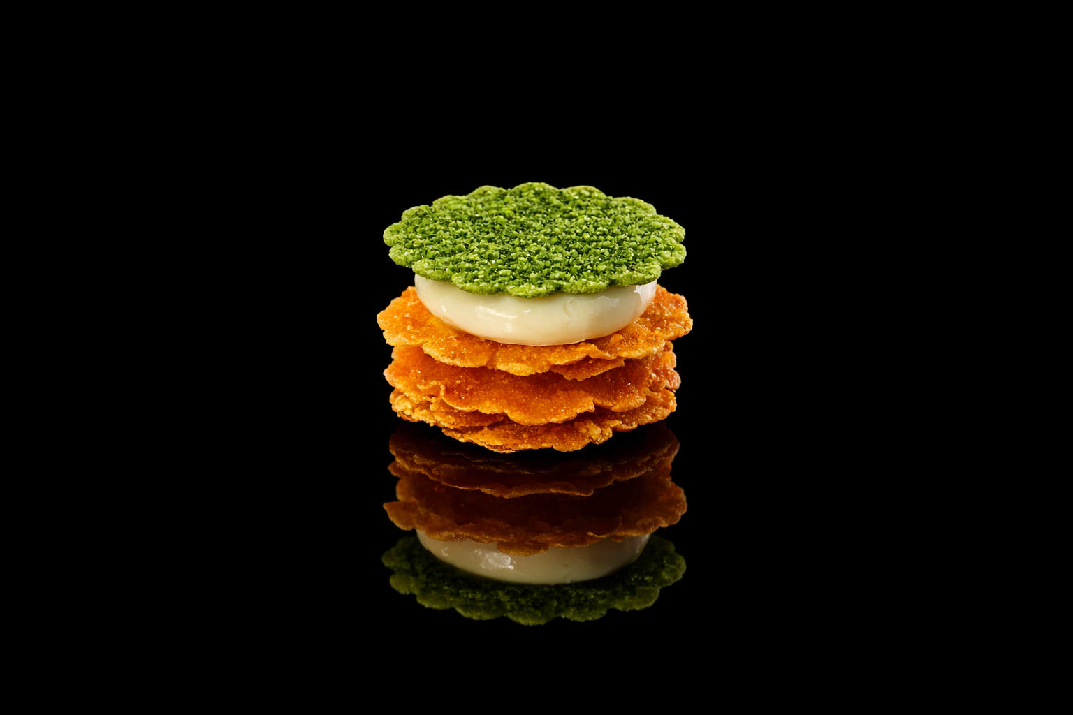 Une pile de quatre nuggets de poulet croustillants avec une œuf dur et une rondelle de concombre sur le dessus, contre un fond noir