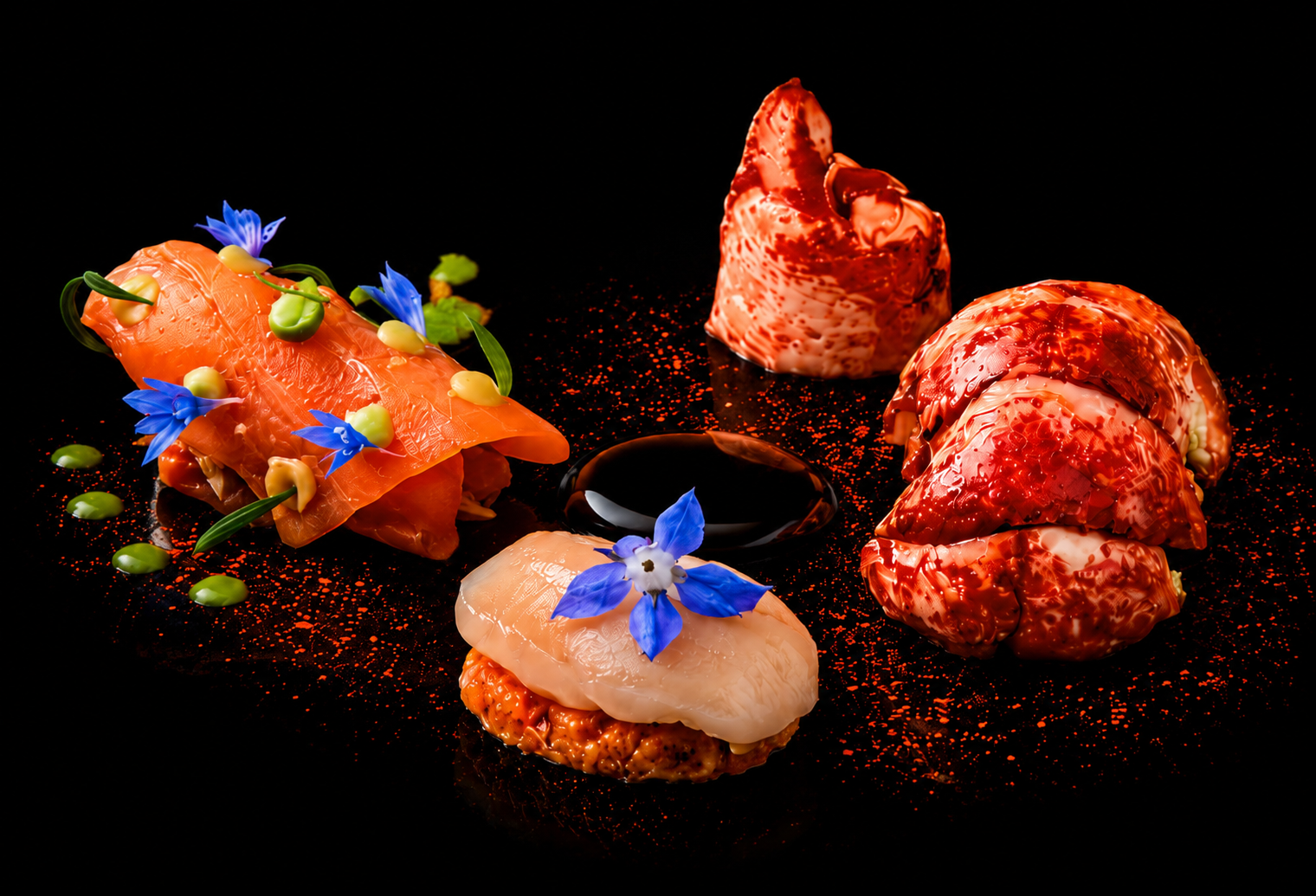 Assortiment de bouchées de viande et de poisson avec fleurs bleues décoratives sur fond noir.
