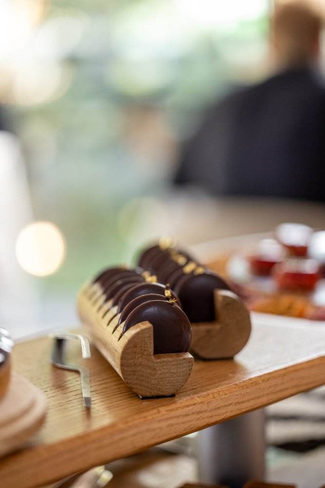 Gâteaux au chocolat décorés avec des feuilles d'or, présentés sur une planche en bois.