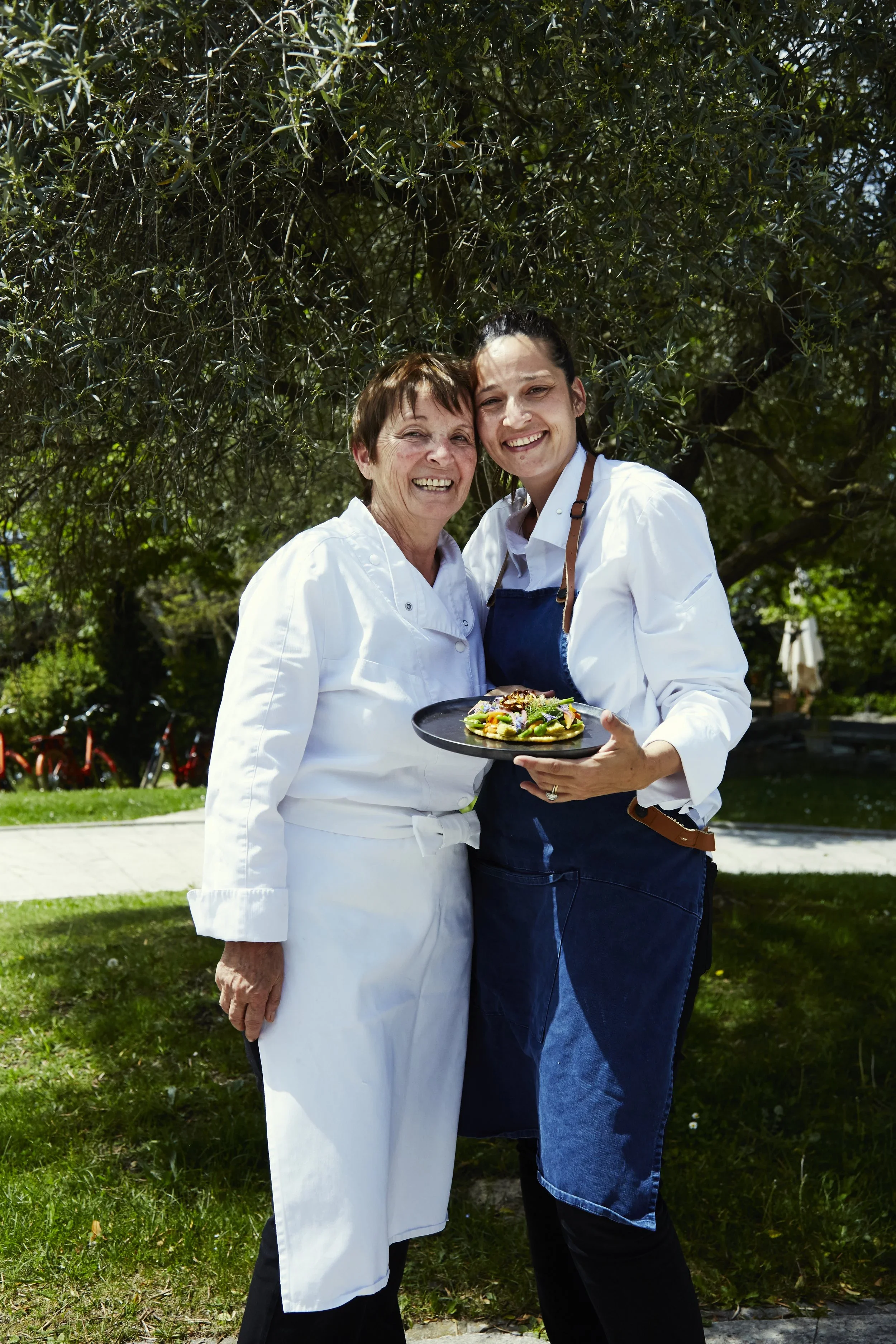Un plat de gastronomie avec un œuf poché dans une sauce, servi sur une assiette blanche ornée d'une fine ligne d'or.