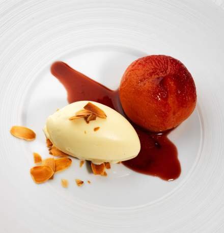 Pêche pochée avec une boule de glace à la vanille, sauce et amandes effilées