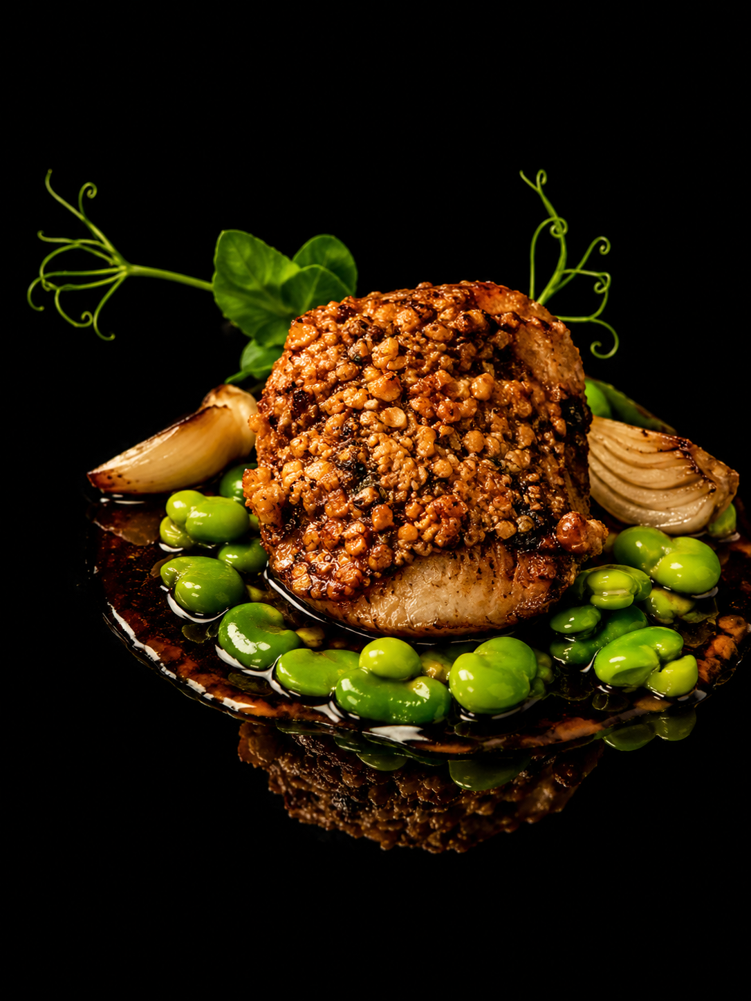 Plat de poisson au croustillant d'airelle, accompagné de pois verts, d'oignons rôtis, et de garnitures vertes