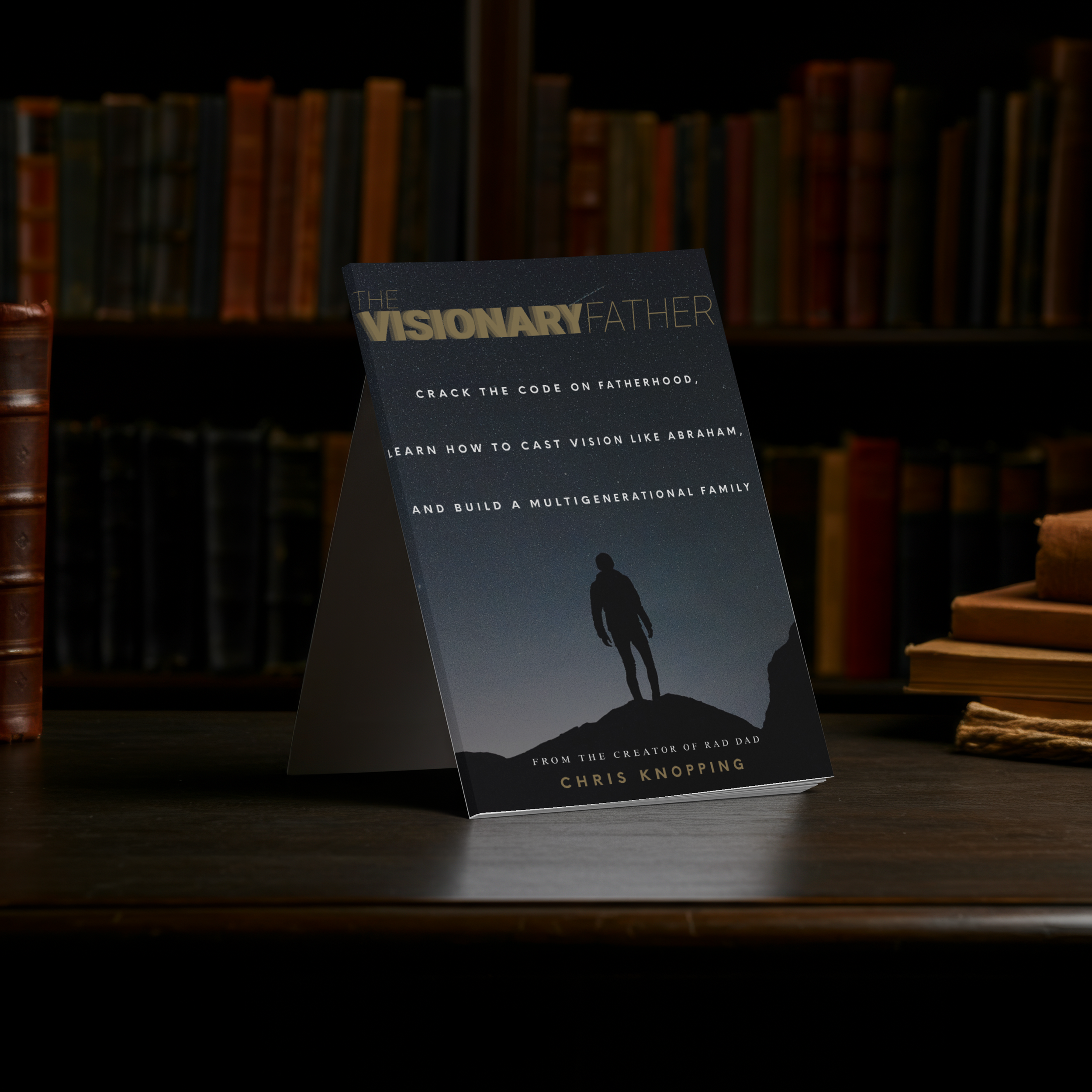 Book titled 'The Visionary Father' by Chris Knopping, standing on a wooden table with bookshelves in the background.