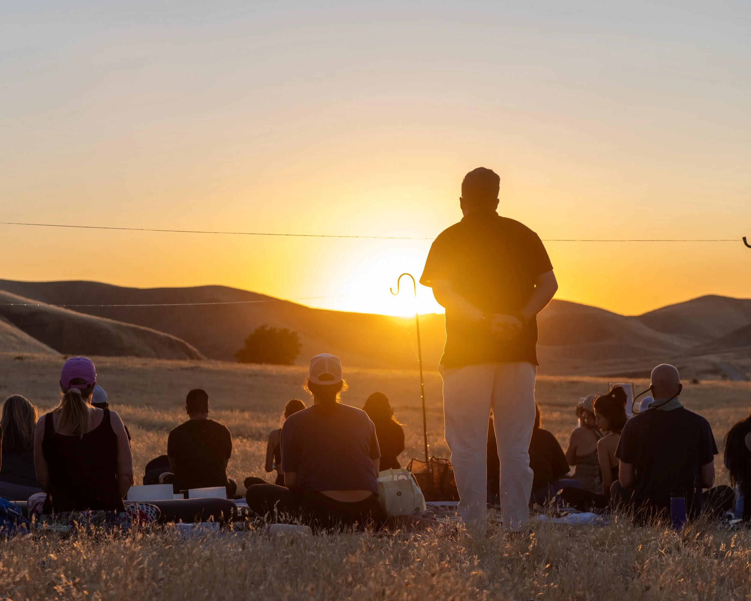 Drew Wiggins holding space during an outdoor sunset practice with Wayfinding Collective community