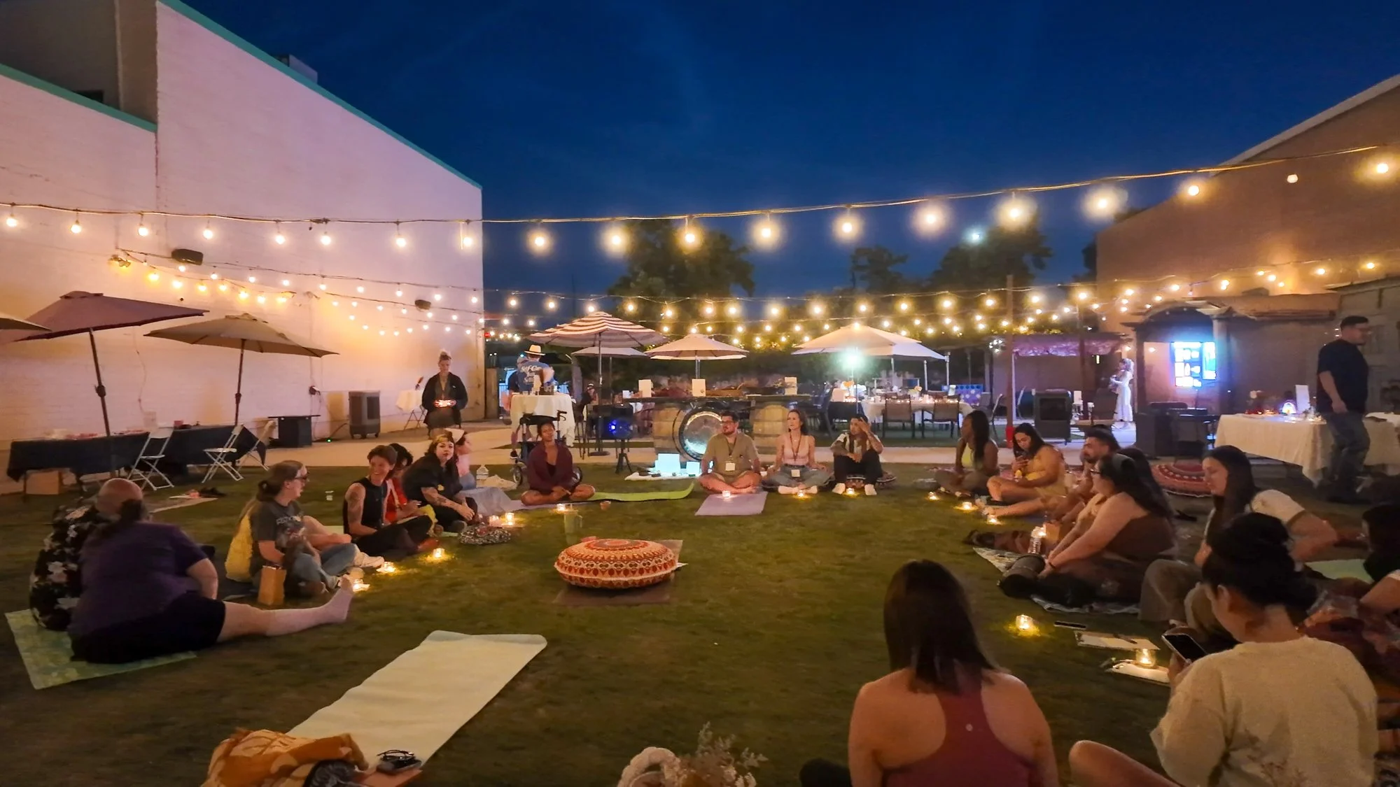 Evening closing circle under string lights at a Wayfinding Collective seasonal gathering