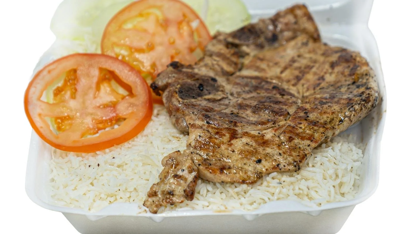 Grilled chicken breast with rice, tomato slices, and lettuce in a takeout container.